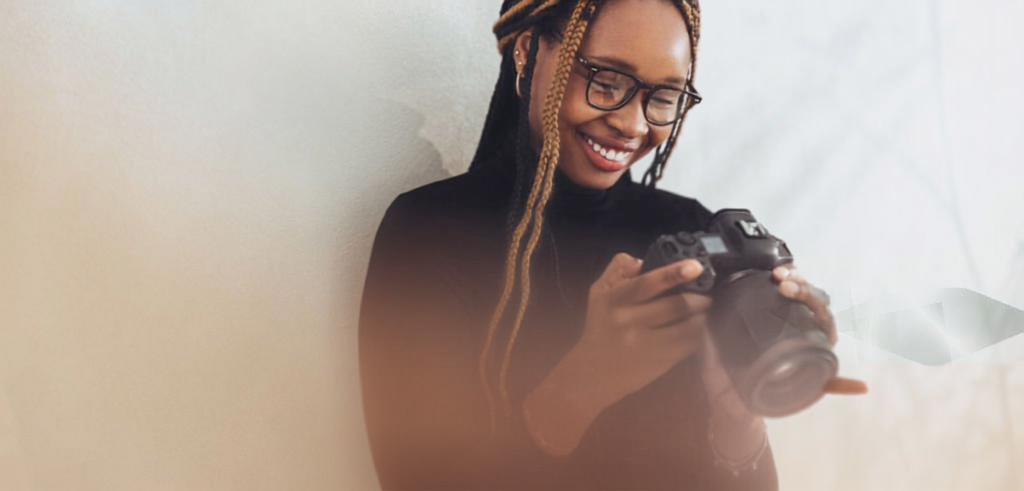 A photographer smiling while reviewing photos on her camera.
